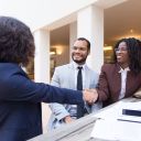 Satisfied customers thanking professional for help and good job. Business man and women sitting at table in outdoor cafe, shaking hands. Partnership concept
